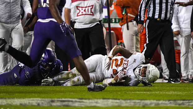 Texas Longhorns running back Jonathon Brooks (24) is brought down by TCU cornerback Josh Newton (3) during the game at Amon G. Carter Stadium on Saturday, Nov. 11, 2023 in Fort Worth, Texas